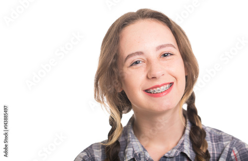 Young girl in a plaid shirt showing her dental braces