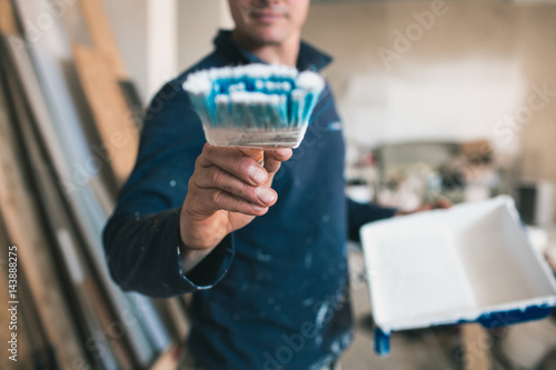 A young man at work. Painter with a brush. Concept of repair