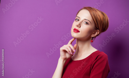 photo of beautiful young woman standing on the wonderful purple studio background © Masson