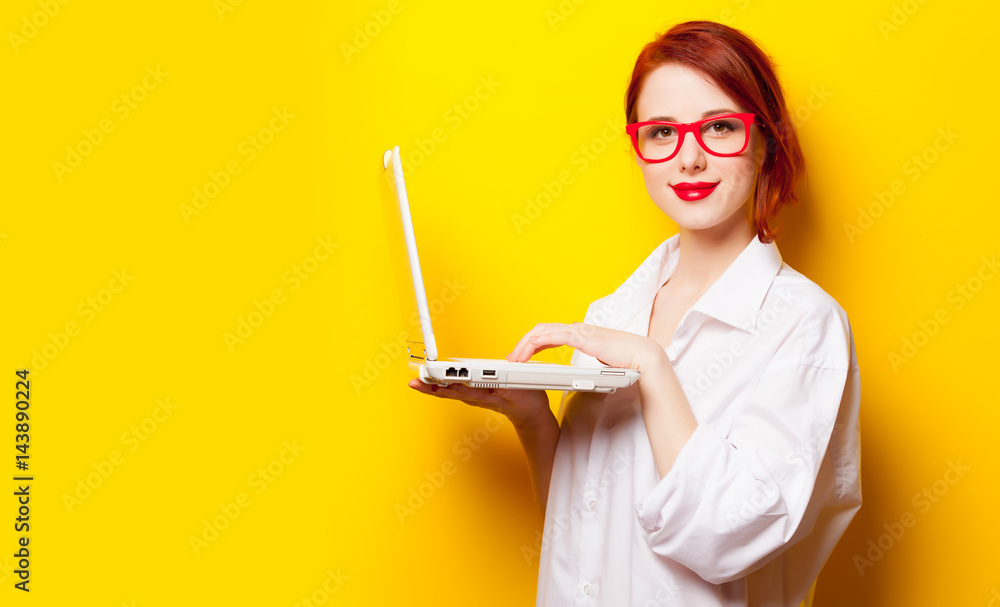 photo of beautiful young woman holding laptop on the wonderful yellow studio background photo of beautiful young woman holding laptop on the wonderful yellow studio background