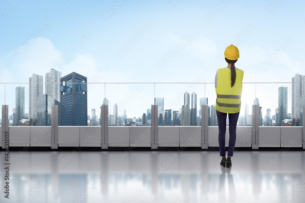 Portrait of asian woman with yellow helmet standing on terrace Portrait of asian woman with yellow helmet standing on terrace