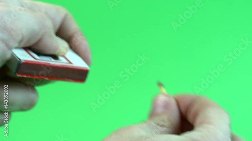 Man's Hands Lighting A Match On Green Screen
