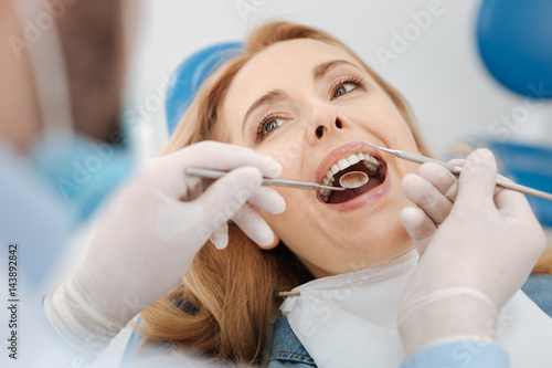 Scrupulous competent dentist cleaning patients teeth