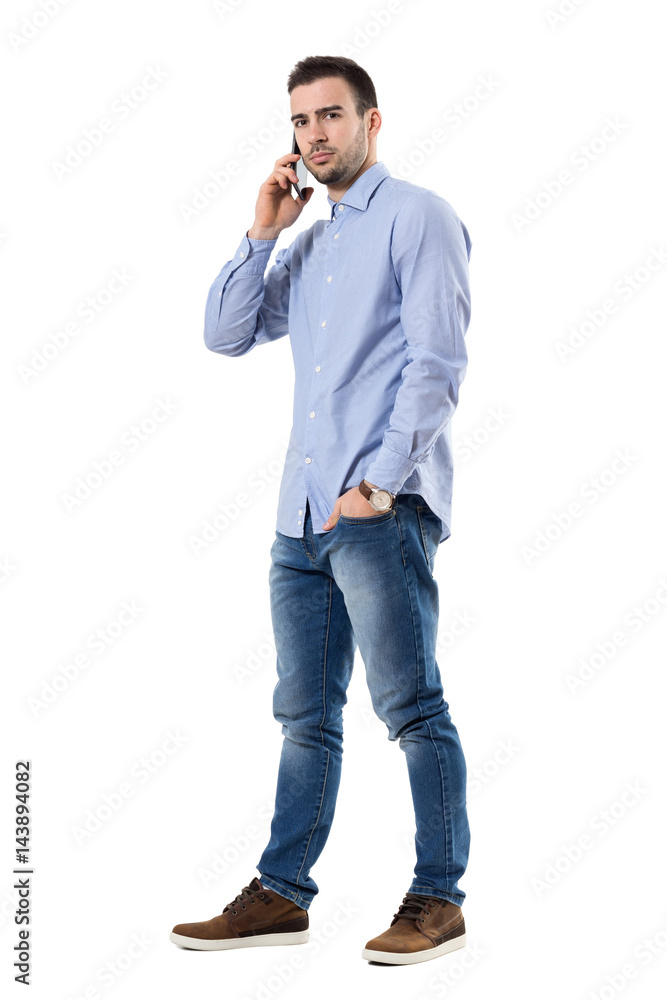 Angry serious businessman talking on the mobile phone looking at camera. Full body length portrait isolated over white background. Angry serious businessman talking on the mobile phone looking at camera. Full body length portrait isolated over white background.