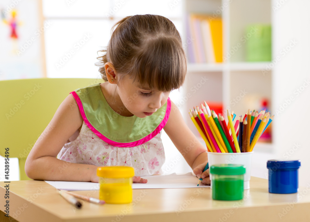 Cute preschooler kid girl drawing with pencils at home Cute preschooler kid girl drawing with pencils at home