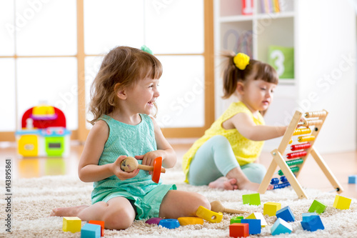 Foto Little kids playing with abacus and constructor toys in kindergarten, playschool