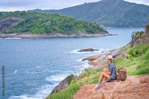 Tourism and photography. Young traveling woman with camera and rucksack enjoying sea view on Phuket, Thailand. © luengo_ua