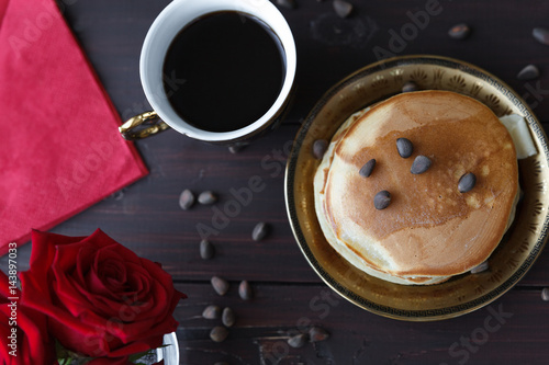 Breakfast coffee and pancakes on the table with roses