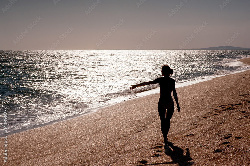 Girl is walking on the idyllic sandy beach