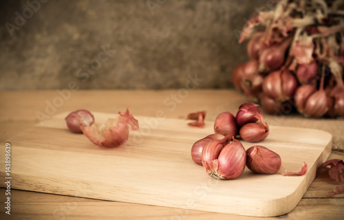 the shallots in bowl on old wooden table with old wallpaper and shallots bunch background