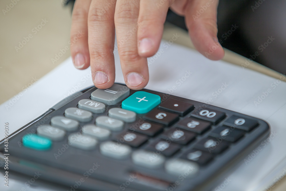 A man is typing something on his calculator and he is making sure all the numbers are correct. A man is typing something on his calculator and he is making sure all the numbers are correct.
