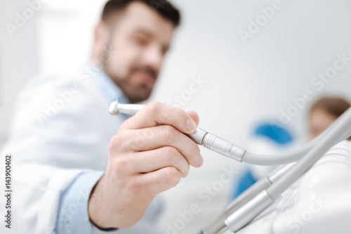 Determined ambitious specialist wanting using a dental drill