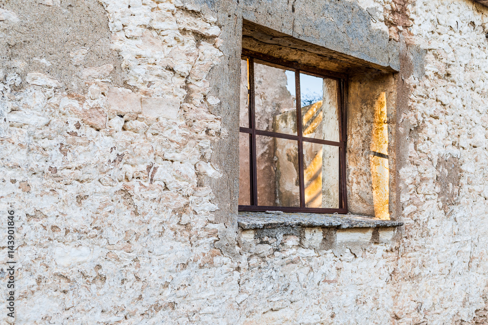 Window in ancient stone wall of ruined building
