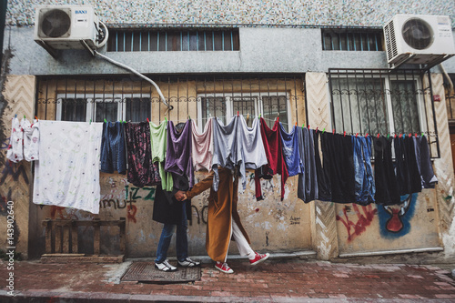 Young couple having fun in drying laundry hanging at old streets of Istanbul