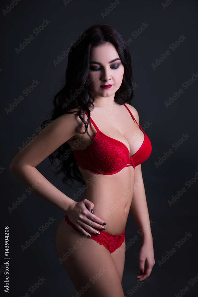 Fototapeta premium sexy young woman in red lace lingerie over black background