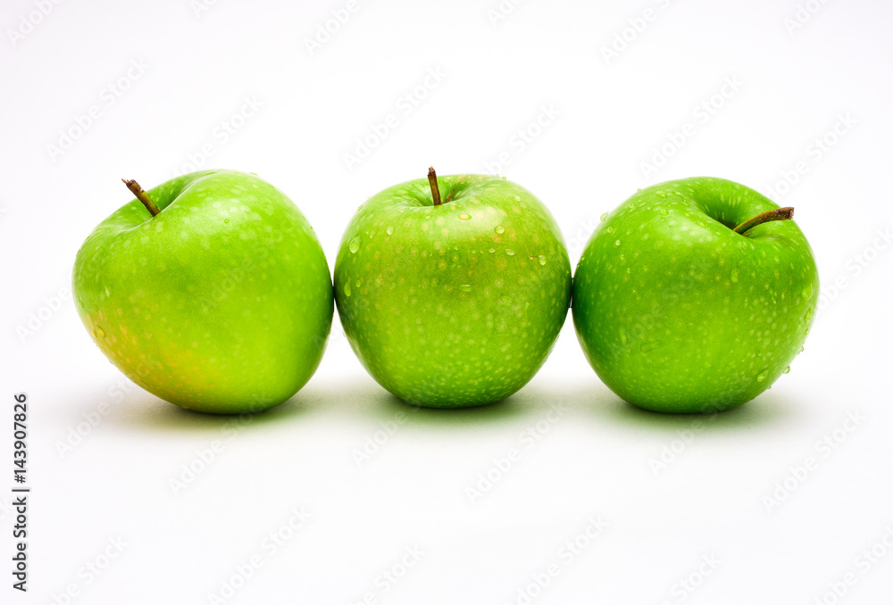 Three green apples for the teacher on a white background with water drops. Three green apples for the teacher on a white background with water drops.