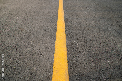 erspective Yellow straight Traffic line on road floor texture and background © ananaline