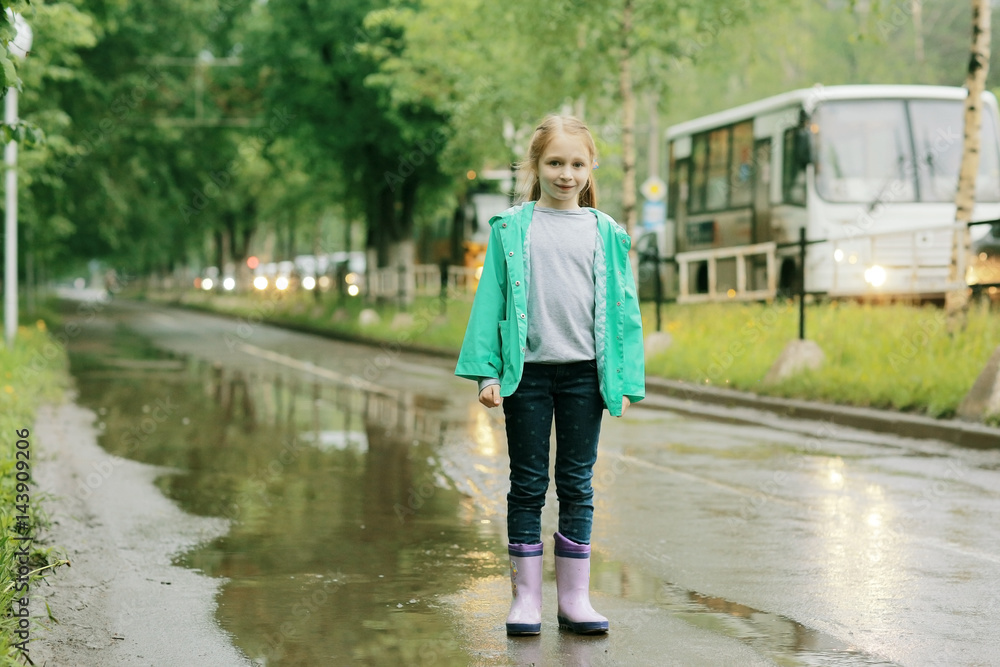 girl jumping in puddles spring rain girl jumping in puddles spring rain