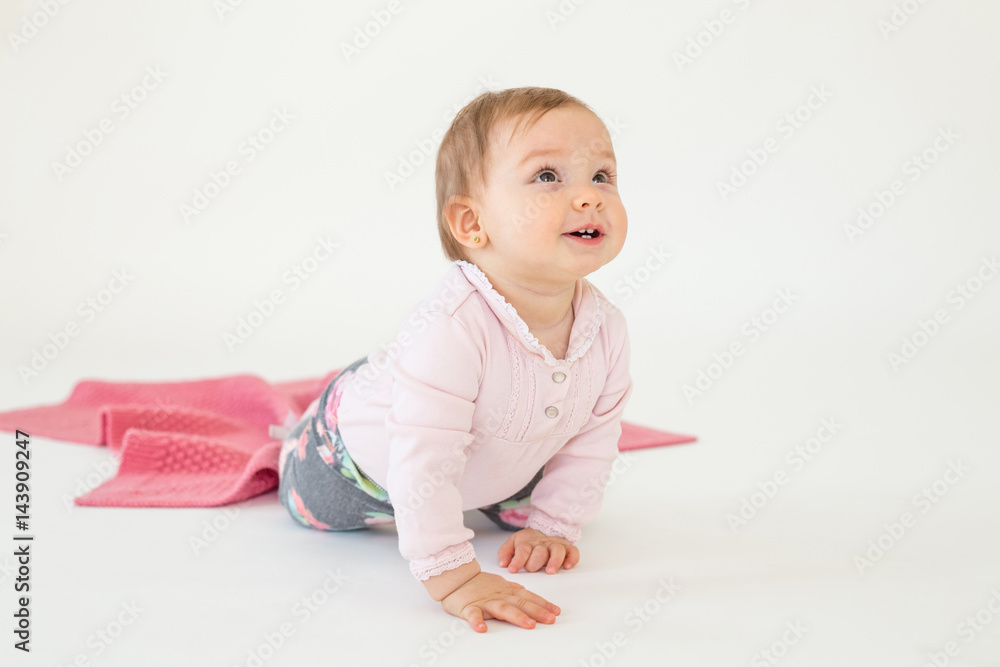 Baby girl sitting on floor isolated over white background Baby girl sitting on floor isolated over white background