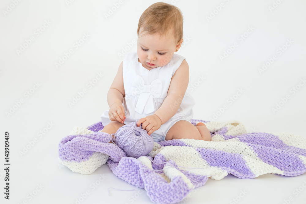 Fototapeta premium Little baby girl playing with threads ball.