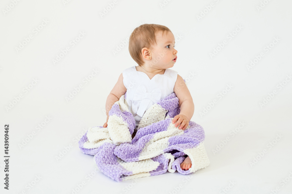 Pretty little baby girl sitting on floor with plaid isolated Pretty little baby girl sitting on floor with plaid isolated