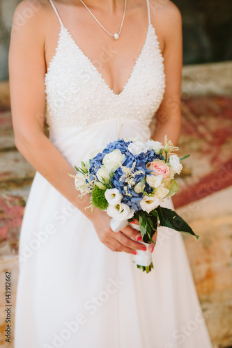 Wedding bridal bouquet of Hydrangeas, Astilba, Lisianthus in the hands of the bride. Wedding in Montenegro, Adriatic.