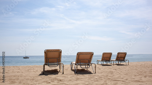 Four beach chairs on the beach. © artjazz