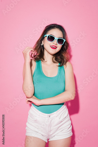 Summer lady. Beautiful asian girl with professional makeup and stylish hairstyle on pink background. © makistock