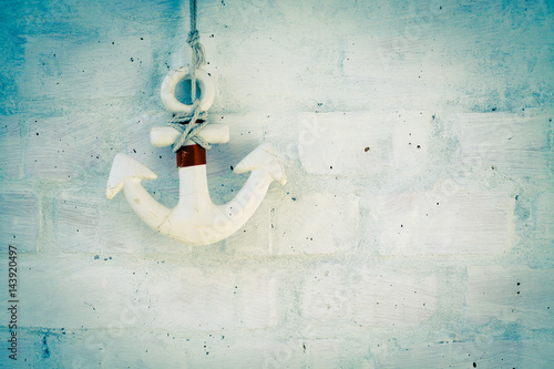 Wooden anchor on brick wall background. photo