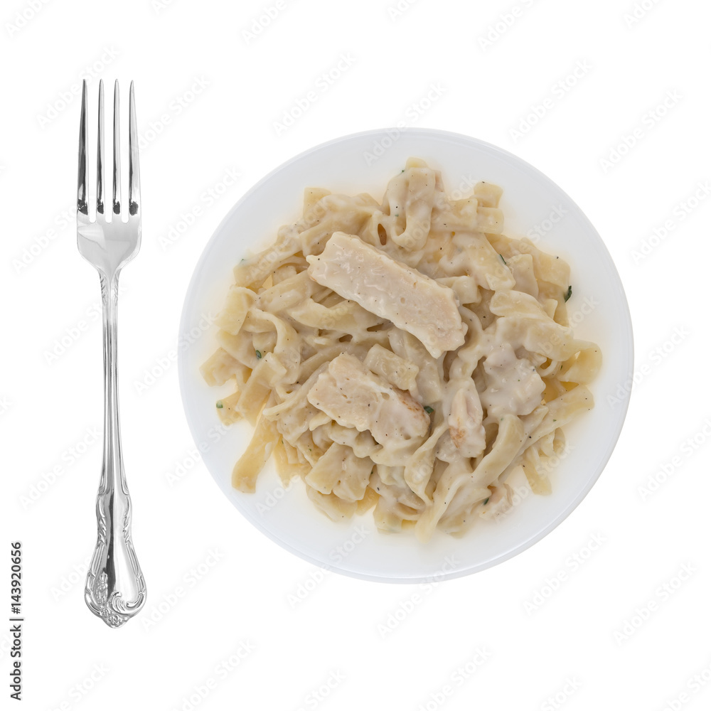 Top view of a plate of fettuccini with chicken plus a fork to the side isolated on a white background. Top view of a plate of fettuccini with chicken plus a fork to the side isolated on a white background.