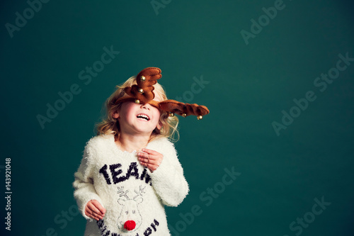 Portrait of young girl wearing Christmas and reindeer antlers photo