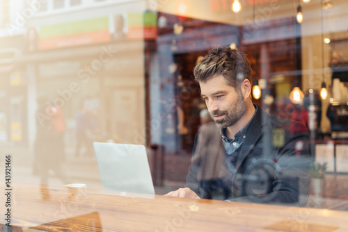 man working on a digital project in a cafe photo