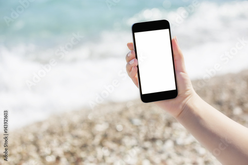 Wallpaper Mural Hand holding a smartphone on a beach Torontodigital.ca