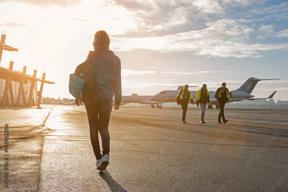 © Yakobchuk Olena - Woman walking at plane parking lot