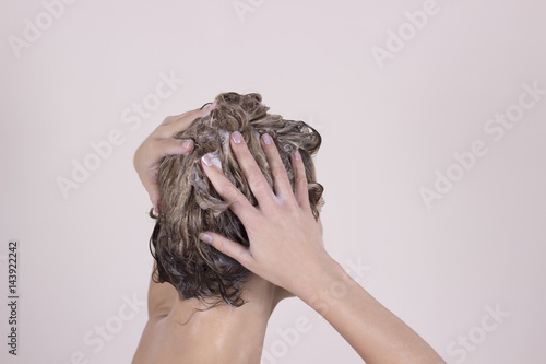 Young attractive woman washing her beautiful long hair