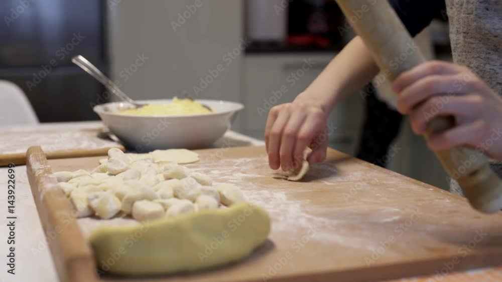 Son helps mother to make dumplings. Preparation of dumplings, traditional Ukrainian cuisine. Son helps mother to make dumplings. Preparation of dumplings, traditional Ukrainian cuisine.