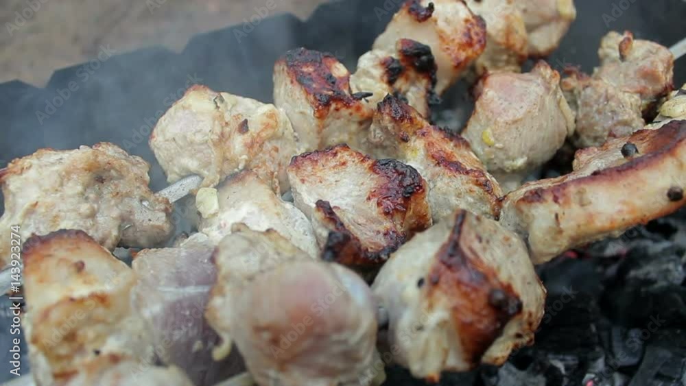 Grilling barbecue meat on wood coal. Man cooks appetizing hot shish kebab on metal skewers. Tasty meat pieces with crust. Grilling food. Cooking shashlik on barbecue grill. Closeup Grilling barbecue meat on wood coal. Man cooks appetizing hot shish kebab on metal skewers. Tasty meat pieces with crust. Grilling food. Cooking shashlik on barbecue grill. Closeup