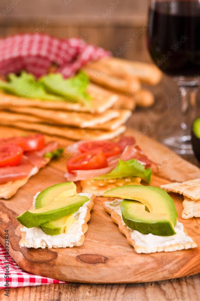 Crackers with ham and avocado. 