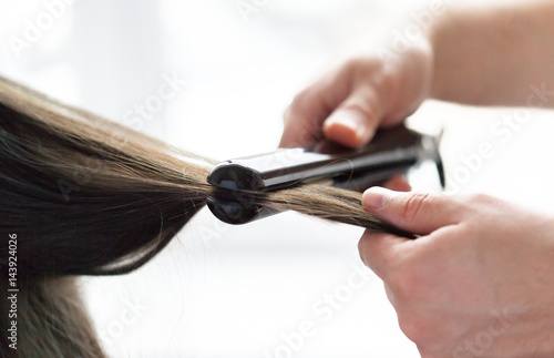 Hairdresser does hair style of woman