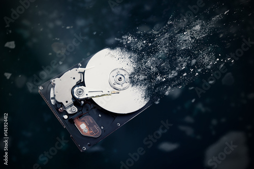 The old hard disk drive is disintegrating in space. Conception of passage of time and obsolete technology photo