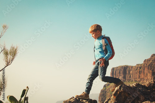 little boy with backpack travel hiking in mountains
