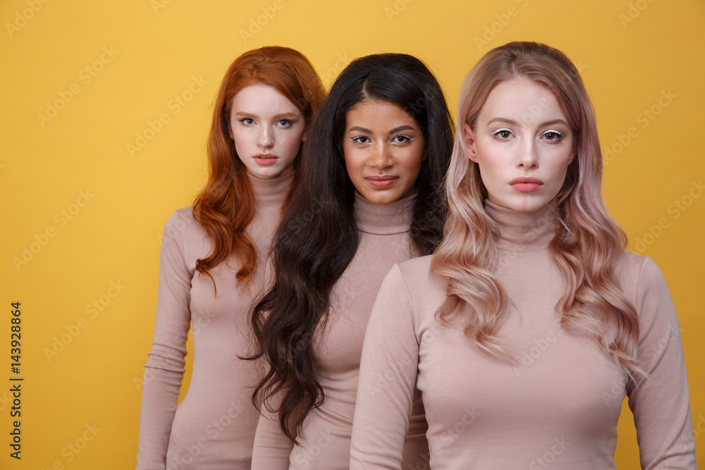 Three calm women standing in studio Three calm women standing in studio