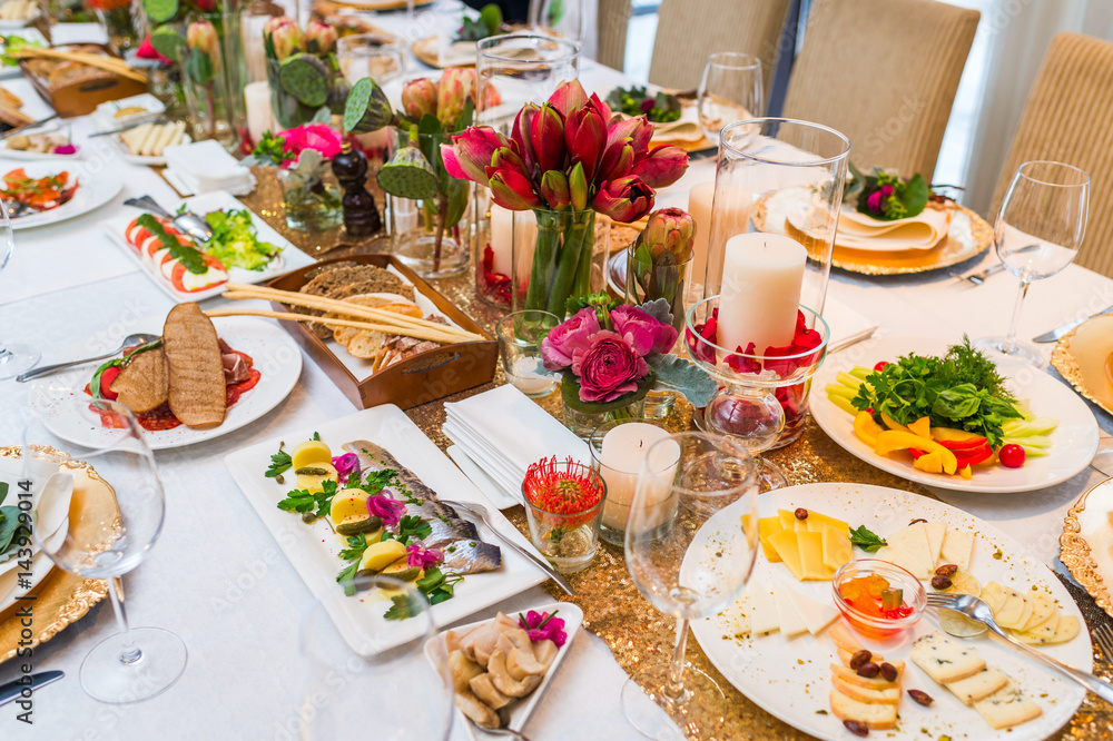 Served table with cold appetizers and decorated with flowers