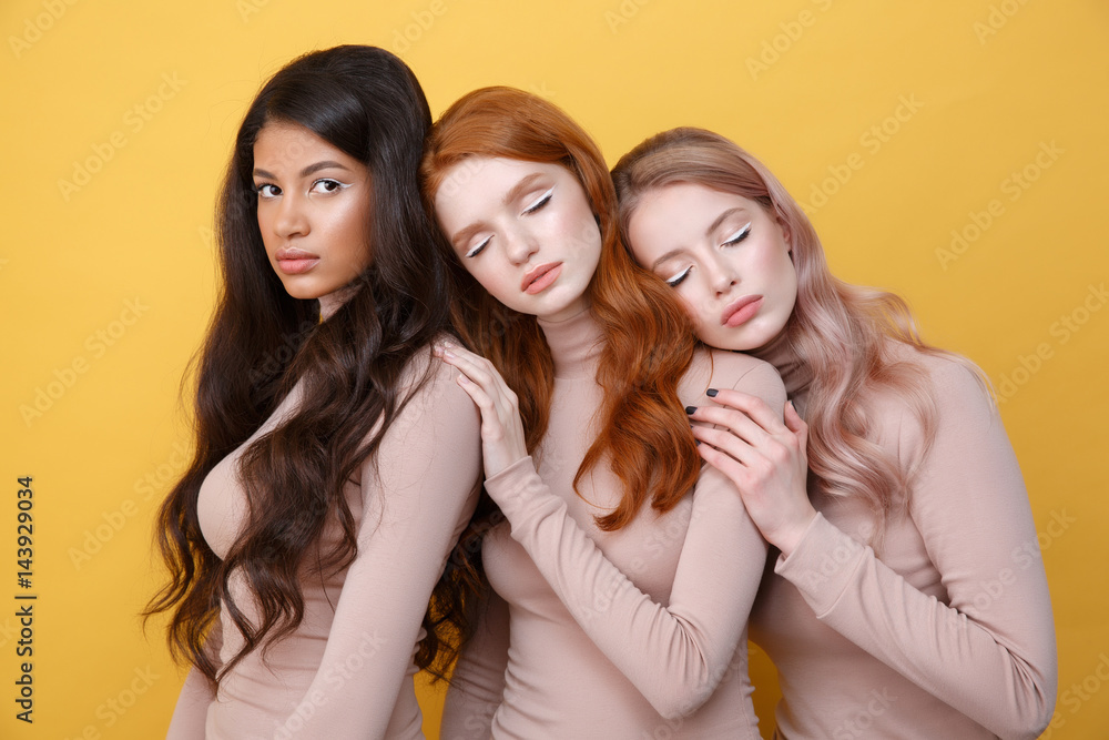 Three young ladies posing in studio Three young ladies posing in studio