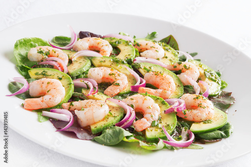 salad a-la carpaccio with prawns, avocado, and red onion sprinkled with black pepper and dressed with olive oil, lemon juice, and finely chopped parsley 