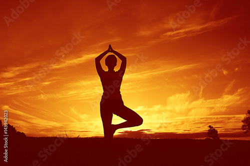 Silhouette of a young girl yoga pose sunset sport