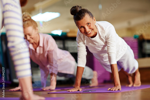 Happy woman doing push-ups on mat