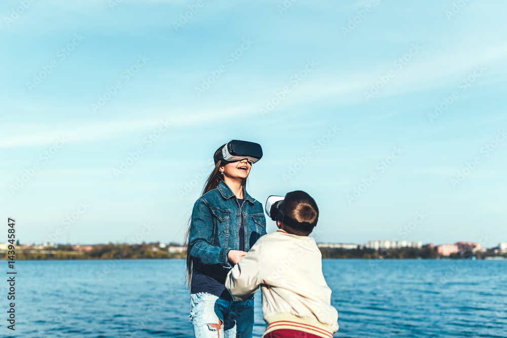 Fototapeta premium Sister with her little brother playing in VR glasses
