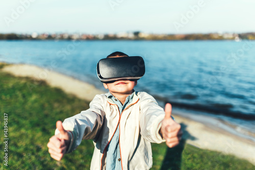Little boy in virtual reality glasses in the park © bedya