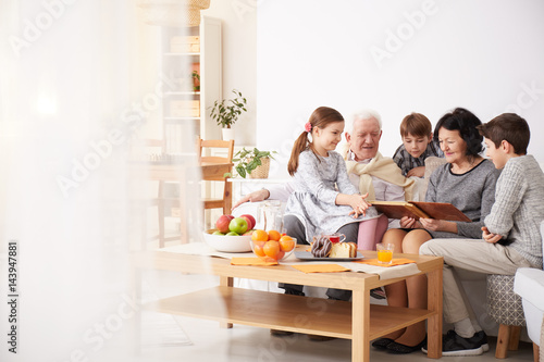 Grandparents showing photo album to their grandchildren